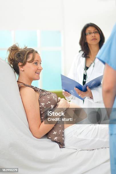 Sonriente Mujer Embarazada Y El Personal De La Clínica Foto de stock y más banco de imágenes de Sala de partos
