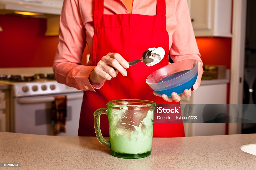 Senior donna in cucina rendendo panna montata. - Foto stock royalty-free di Adulto
