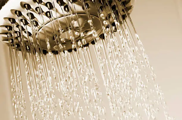 Photo of Water spraying from shower head with black jets