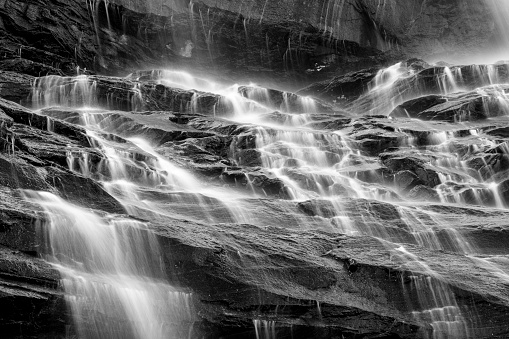 Black and white dramatic waterfall under old stone bridge deep in the English Lake District