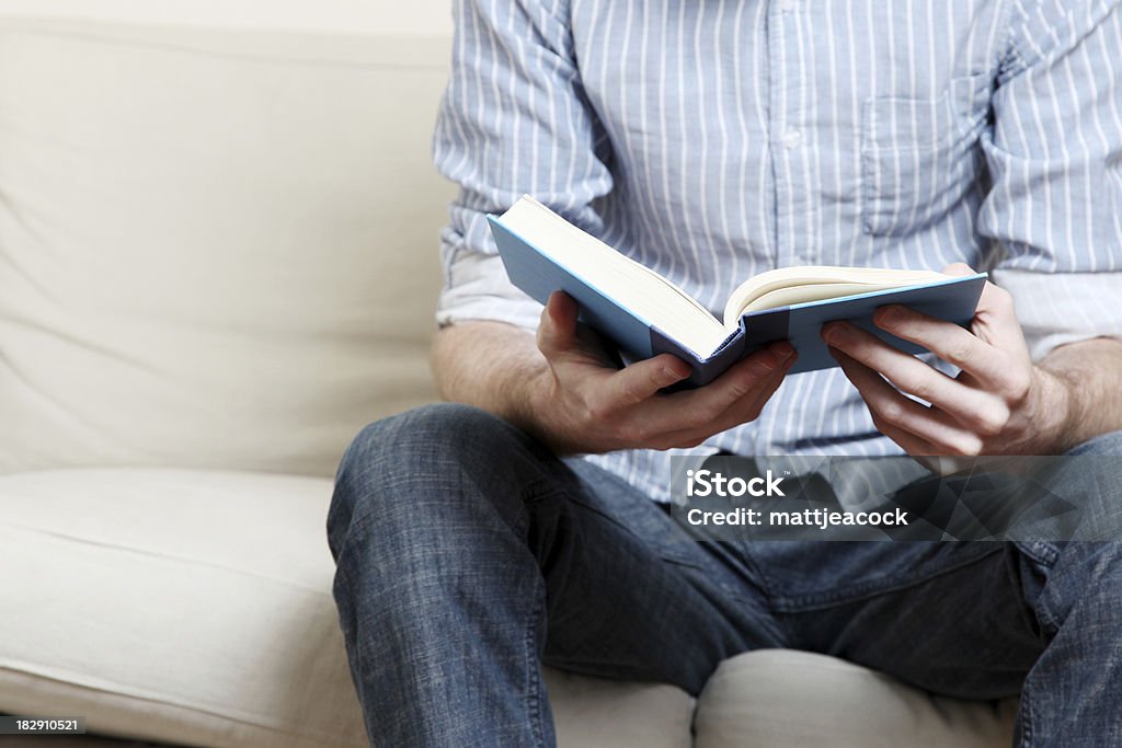 Reading Male in blue plaid shirt reading a book Adult Stock Photo