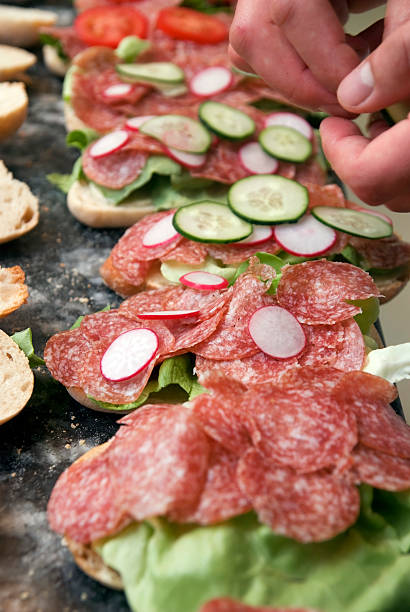 making many sandwiches with salami for buffet party