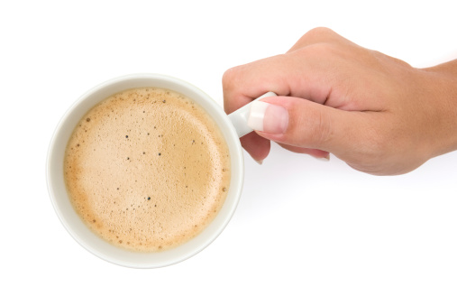 Female hand holding a cup of fresh coffee. White background.