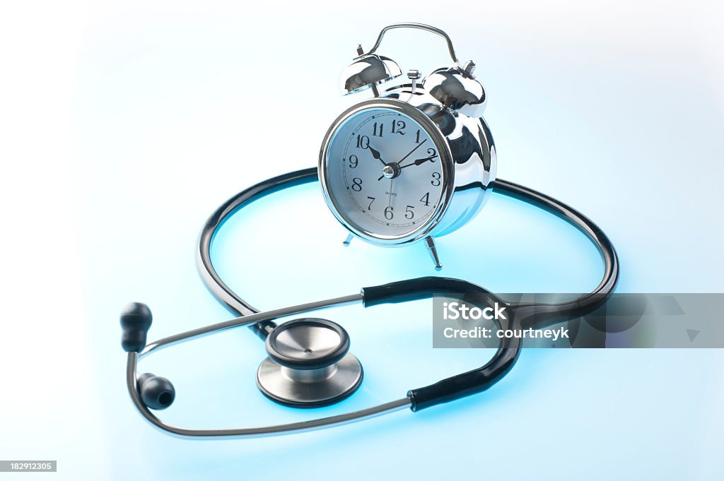 Stethoscope and clock Stethoscope and clock on blue and white background Alarm Clock Stock Photo