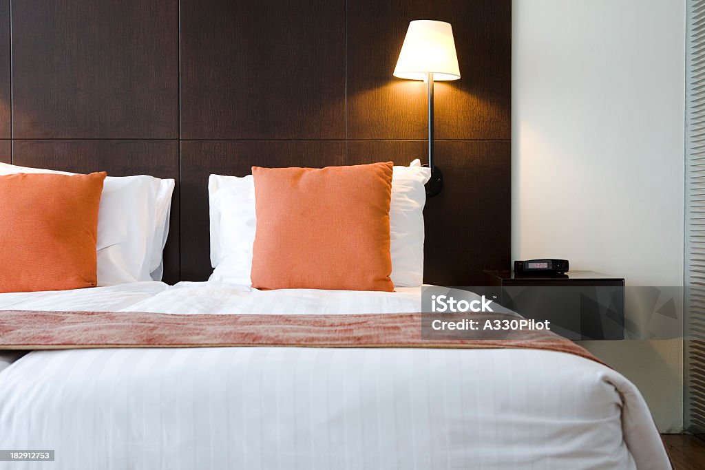 Bed in hotel room with orange pillows  Modern hotel room. Hotel Room Stock Photo