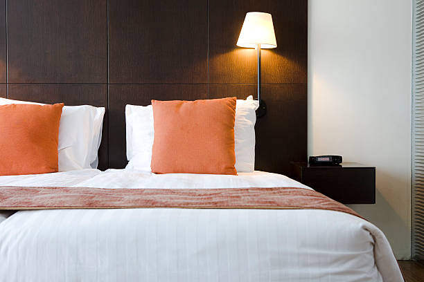 Bed in hotel room with orange pillows  stock photo