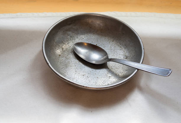 Empty aluminium plate and spoon Grande Chartreuse, France - September 30, 2023: Modest Aluminum plate and spoon of the Carthusian monks prison meal stock pictures, royalty-free photos & images