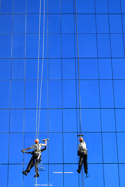 Two suspended workers cleaning the building glass