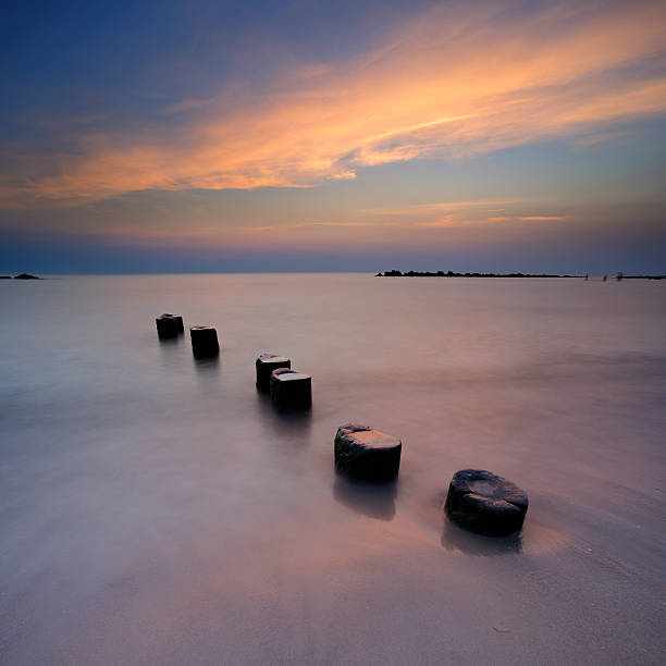 Tranquil Seascape with Old Wooden Posts at Sunset