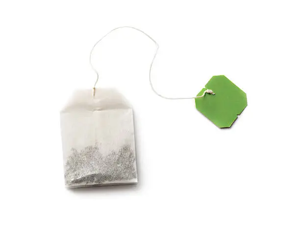 "Tea bag with green label isolated on white, It may be herbal, green or black tea"