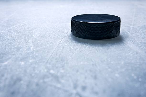Hockey Puck A hockey puck on ice textured by skate marks.Click on an hockey puck stock pictures, royalty-free photos & images