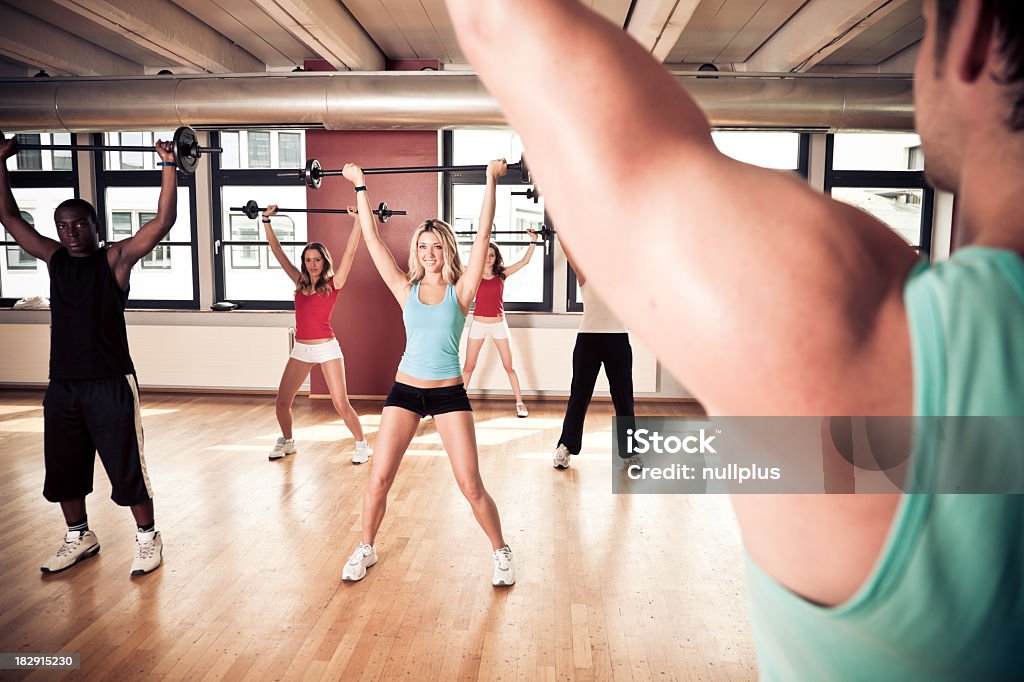 young people at the gym young people working out at the gym, the instructor showing some weight lifting exercises 20-29 Years Stock Photo