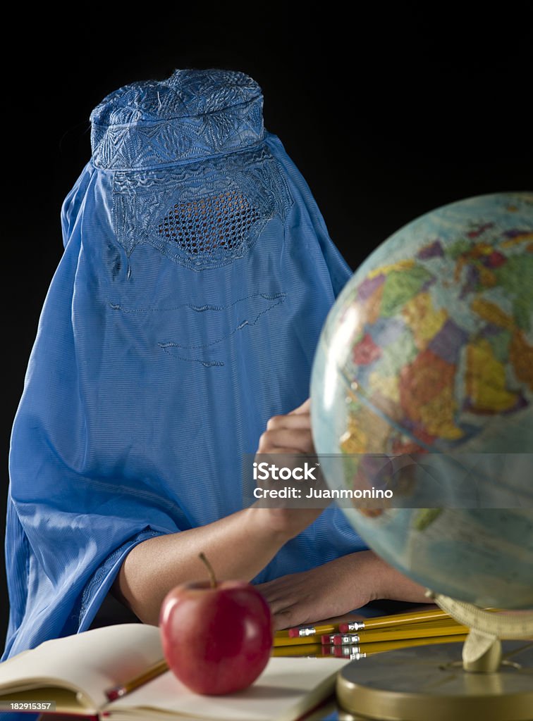 Little Afghan Girl at the School Little Afghan Girl at the School pointing at a desktop globe map on black background (this picture has been taken with a Hasselblad H3D II 31 megapixels camera) Afghanistan Stock Photo