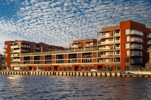 New residential buildings construction. Contemporary brick houses on the riverbank. Autumn cityscape
