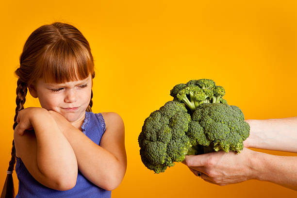 istock Little Red-Haired Girl Disgusted with Broccoli 182915441