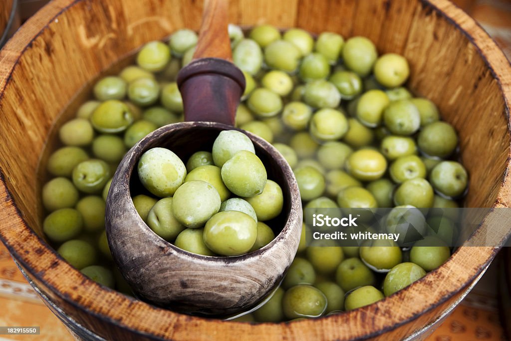 Cuchara de verde aceitunas en una bañera de hidromasaje - Foto de stock de Aceituna libre de derechos