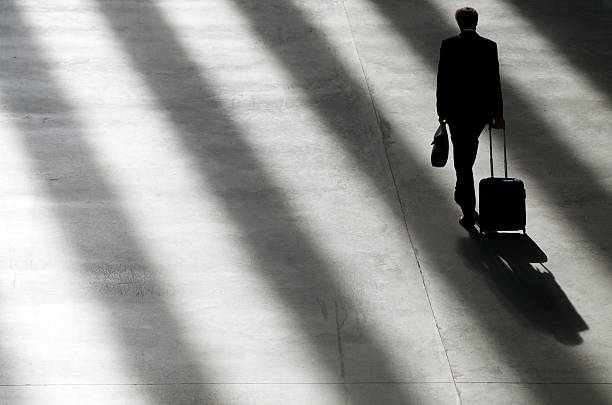 istock Traveling Businessman Walking Suitcase Into Shadows 182915887
