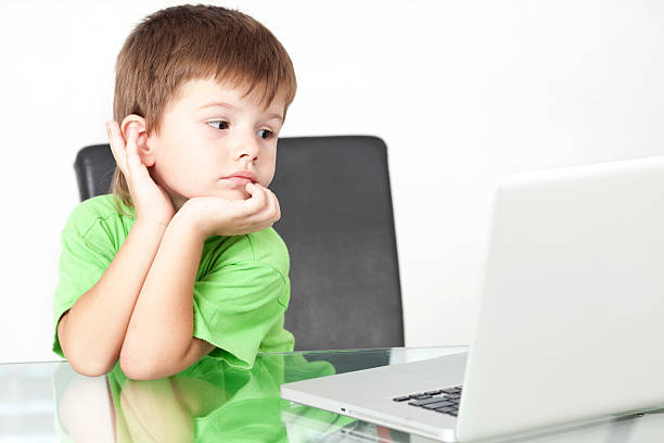 istock Boy staring at the laptop's screen in office. 182916261