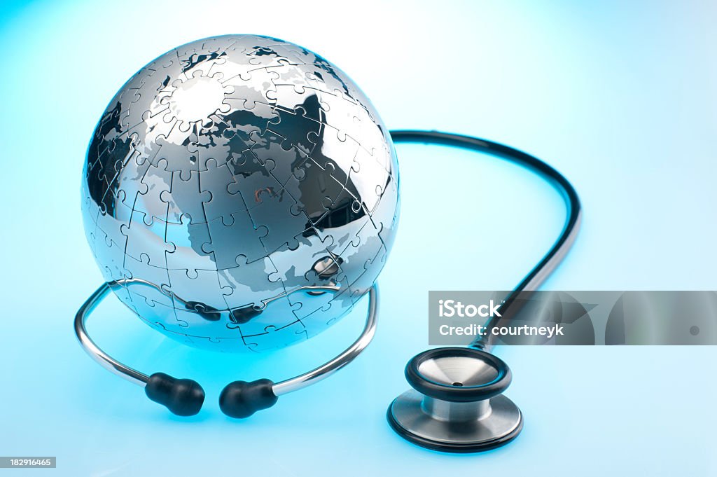 Stethoscope and chrome earth globe puzzle. Stethoscope and metal earth globe on blue and white background. Shows North America Globe - Navigational Equipment Stock Photo