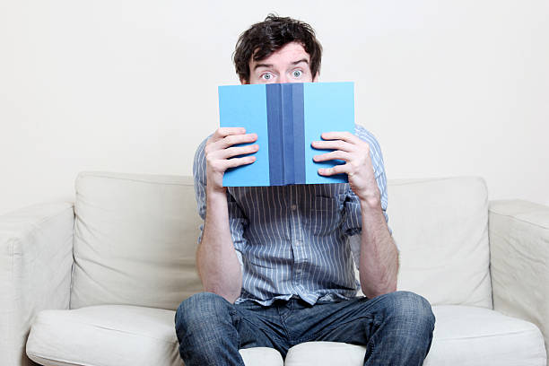 istock Male in blue shirt reading a book 182917022