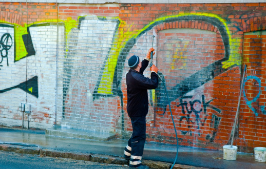A man removing graffiti
