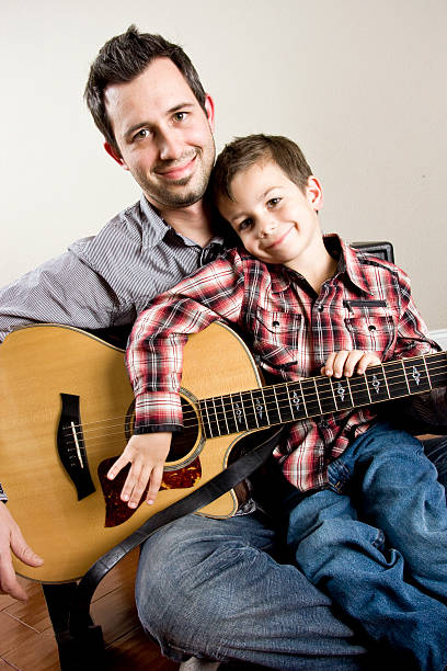 Father and son playing guitar portrait of a father and his son playing the guitar father and son guitar stock pictures, royalty-free photos & images