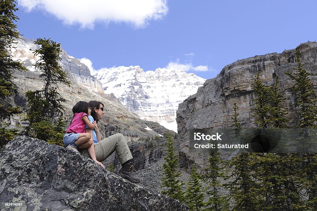 Daughter Hugging Her Mother While Relaxing in the Mountains "A daughter hugs her mom as the two sit on a rock, relaxing during a hike through the mountains. (Yoho National Park, British Columbia)" Active Lifestyle Stock Photo