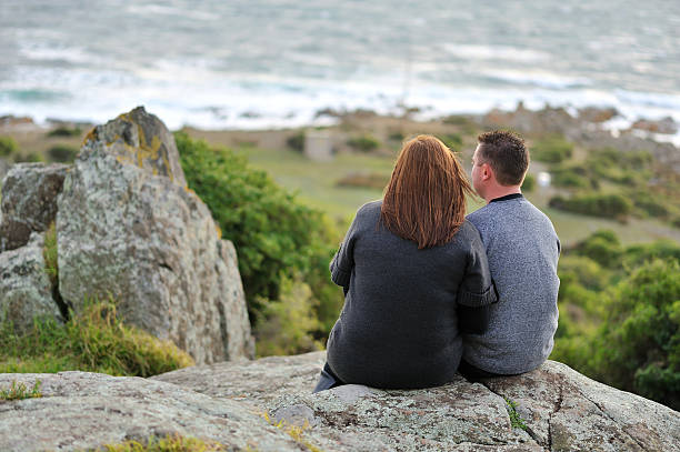 istock Rear view of a young couple romancing while sitting 182919453