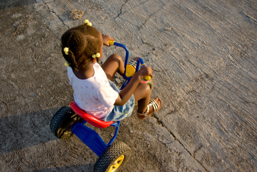 child riding tricycle on pavement
