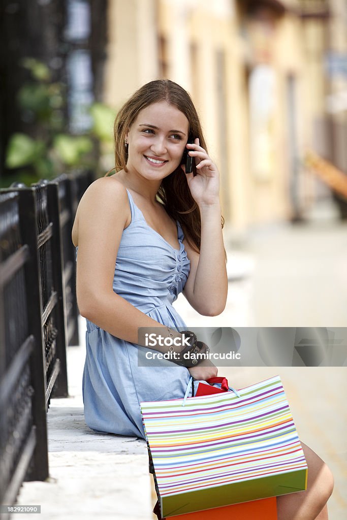 Jovem mulher com sacos de compras, falando no telefone celular - Foto de stock de 20 Anos royalty-free