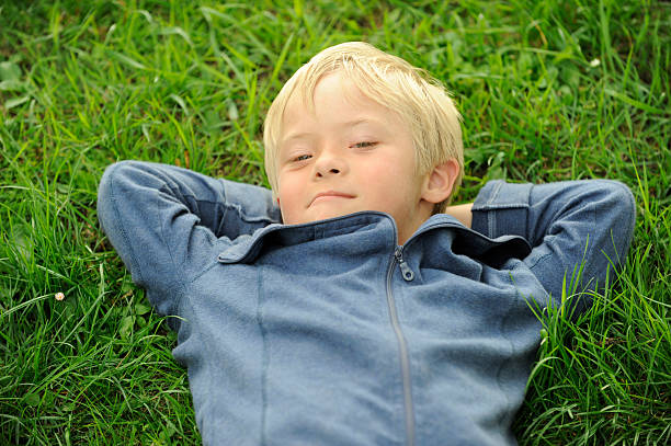 istock Boy with down syndrome lying in the grass 182924320