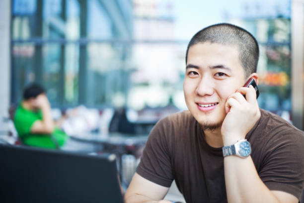 Communication everywhere Young man talking onthe phone. crew cut stock pictures, royalty-free photos & images