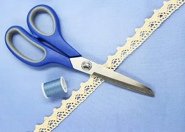 "Scissors, lace and fabric for sewing or craft."