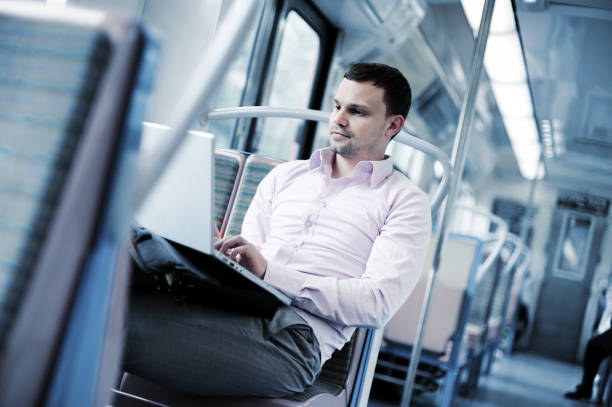 Businessman on Commuter Train with Laptop Computer
