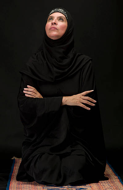 istock Muslim woman kneeling on black background 182924987