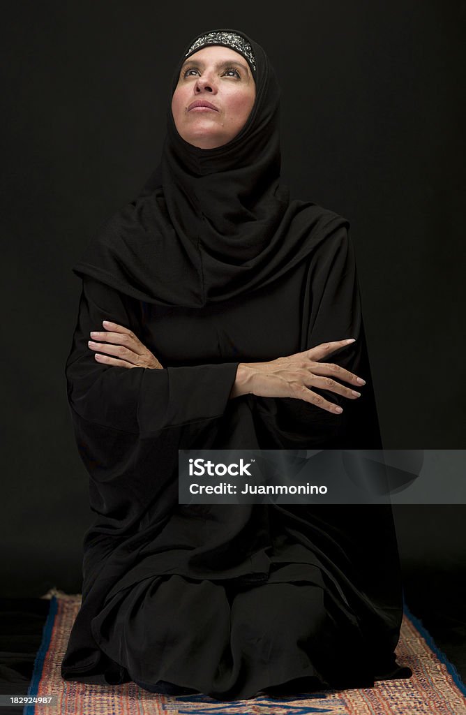 Mulher muçulmana Ajoelhar em fundo preto - Royalty-free Mulheres Foto de stock