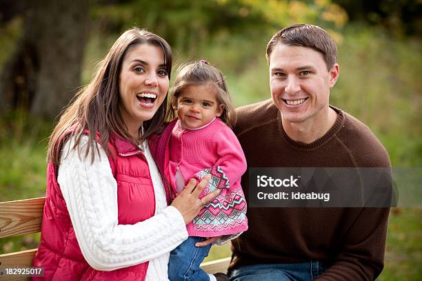 Familia Feliz Sentado En El Banco En El Bosque En Otoño Foto de stock y más banco de imágenes de Adulto