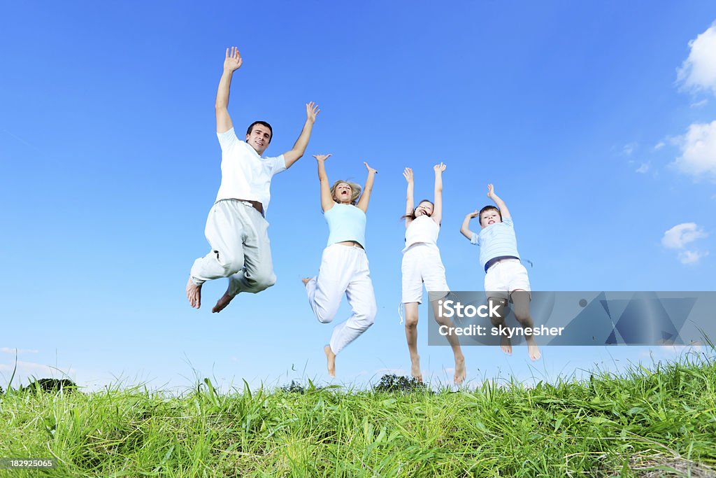 Família pulando na meadow. - Foto de stock de Família royalty-free