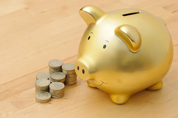 piggy bank - piggy bank gold british currency pound symbol - fotografias e filmes do acervo