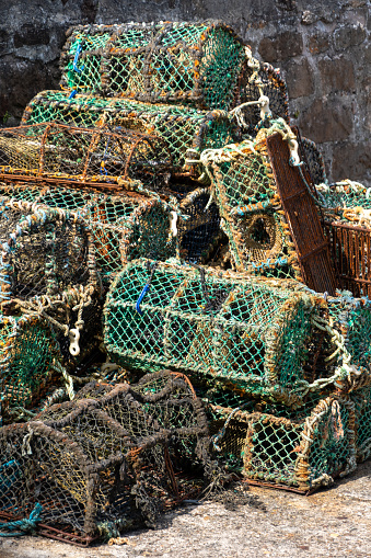 Large stack of commercial lobster traps with green netting