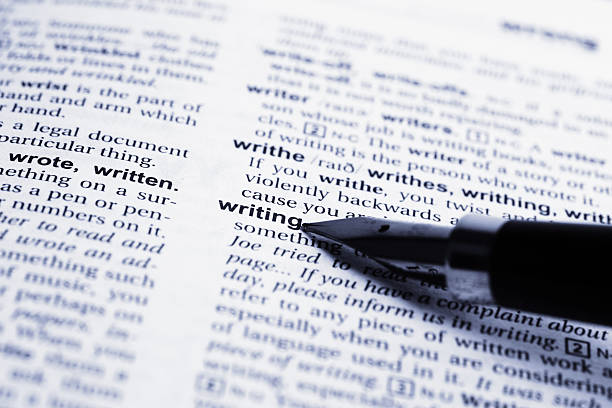 Fountain pen pointing to the word writing in a dictionary stock photo