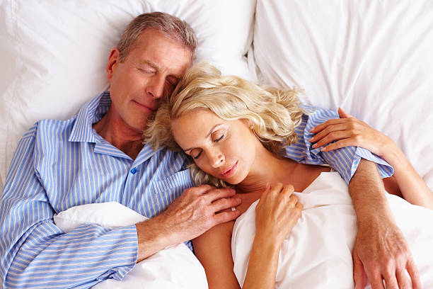 man sleeping in bed with woman - ogen dicht closeup vrouw 50 jaar stockfoto's en -beelden