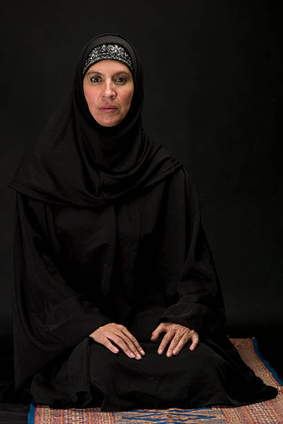 istock Muslim woman kneeling on black background 182927875