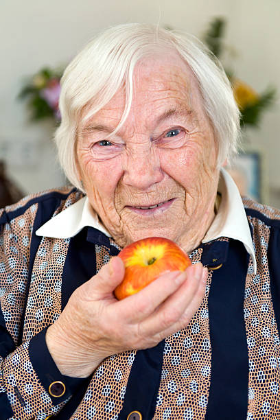 istock Female Senior holding a ripe apple in her hand 182927898