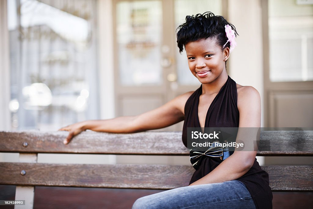 Süße Modische junge Frau sitzt auf der Bank lächelnd - Lizenzfrei Afrikaner Stock-Foto