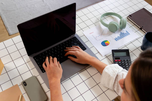 istock High angle view of businesswoman using laptop while sitting at office desk 1829292423