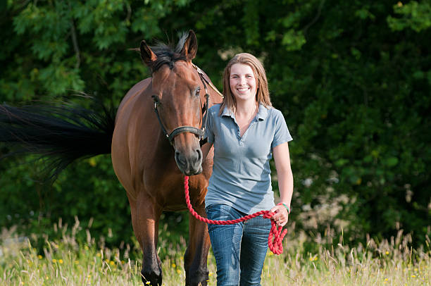 istock Happy young woman walking her horse 182929306