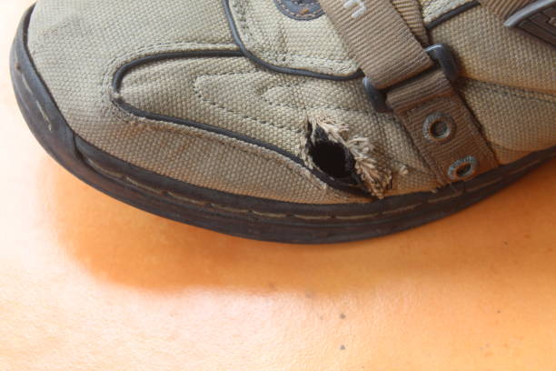 istock Broken and torn men's casual shoes on brown floor 1829293443
