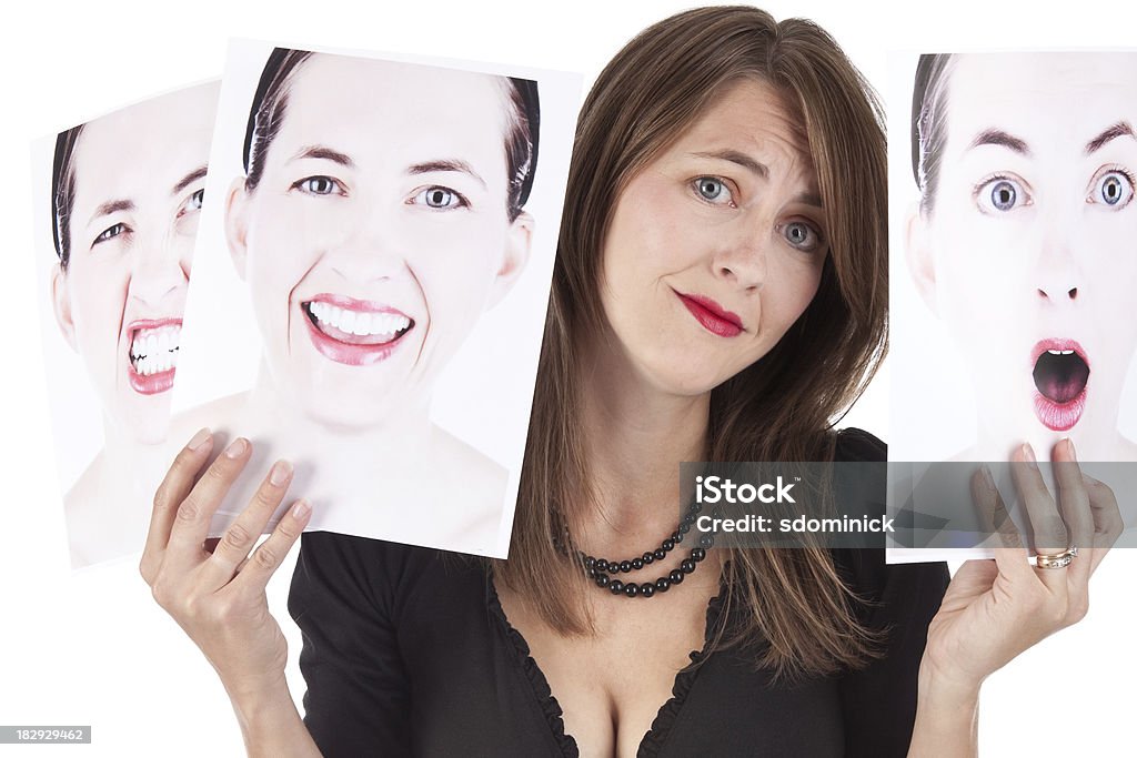 Confundida mujer agarrando fotografías de sus emociones - Foto de stock de Trastorno bipolar libre de derechos
