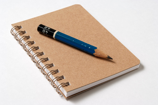 Aislado fotografía de cuaderno con espiral con lápiz sobre fondo blanco photo